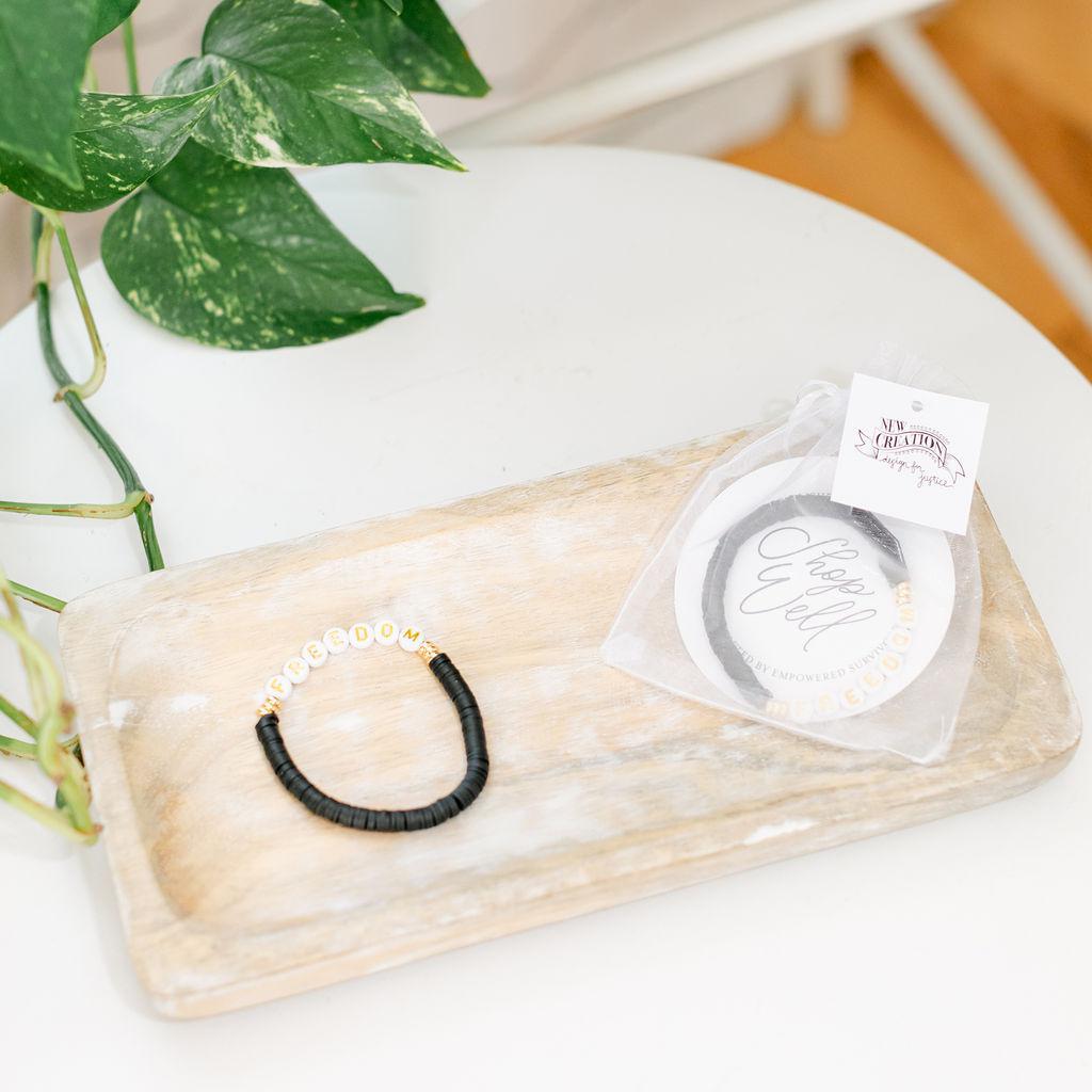 A pair of black bracelets saying &