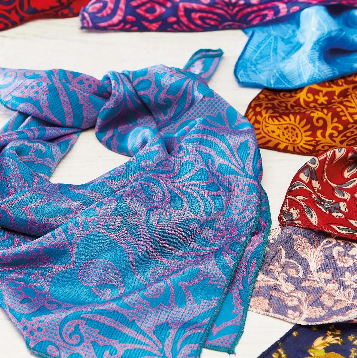 Colorful patterned fabric scarves on a white surface