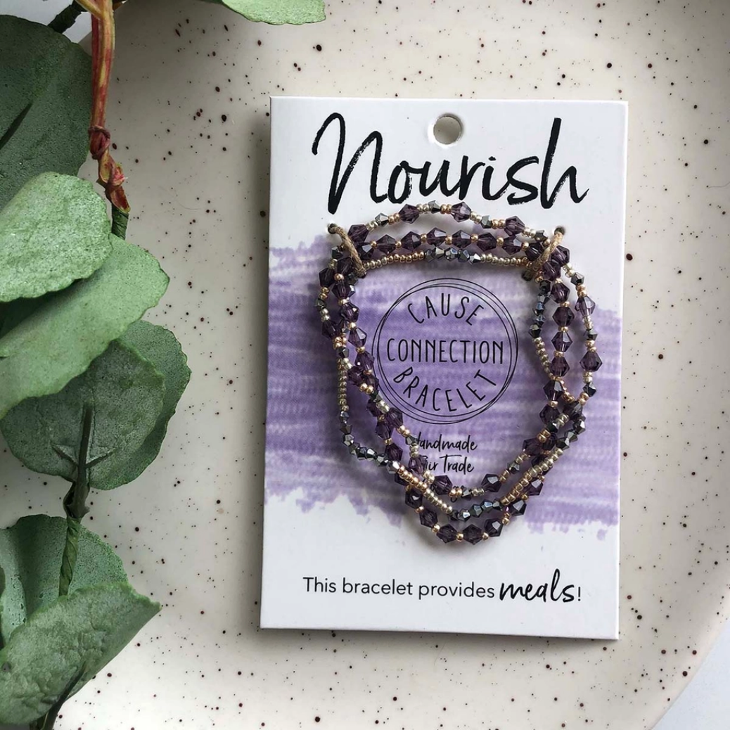 a multi-strand cause bracelet saying Nourish on a white tag with a plant in the background