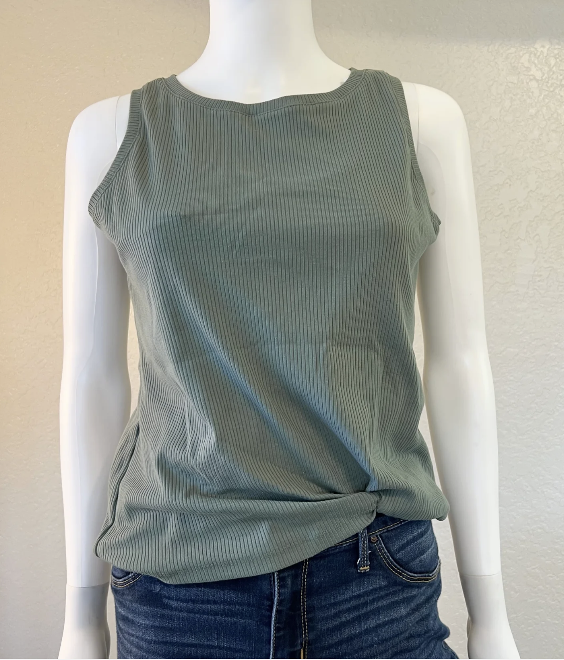 Green ribbed tank top on a mannequin with a plain background