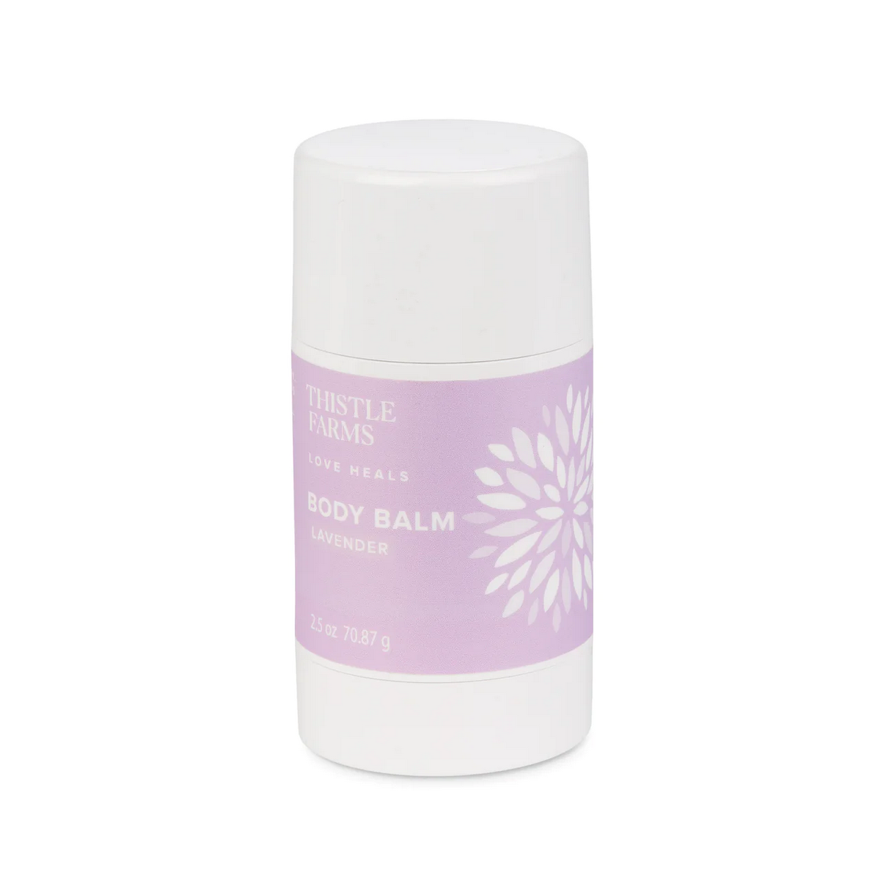 A container of Soothing Body Balm by Thistle Farms placed on a wooden surface with green plants in the background.