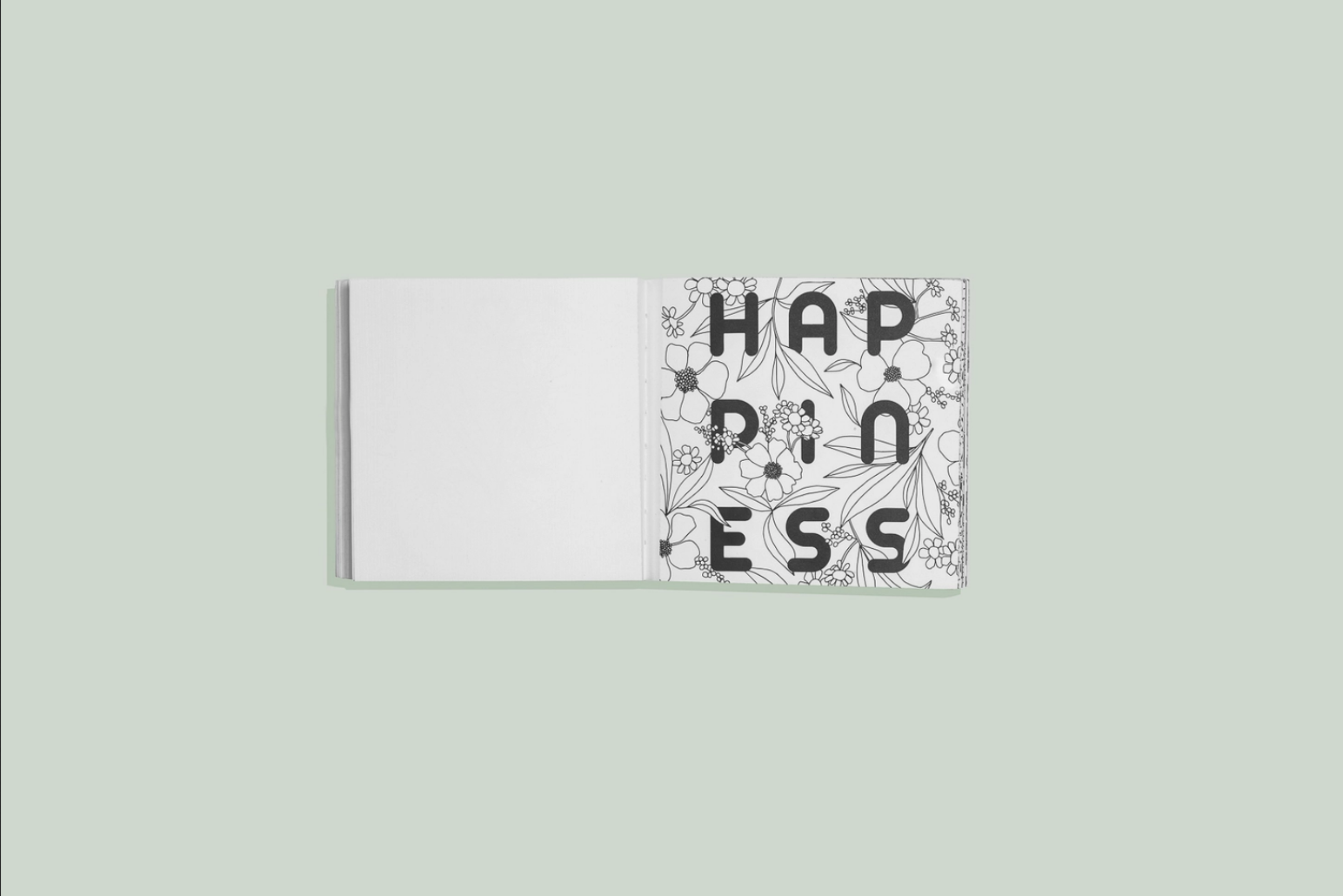 A coloring book laid open saying "Happiness" with a green background