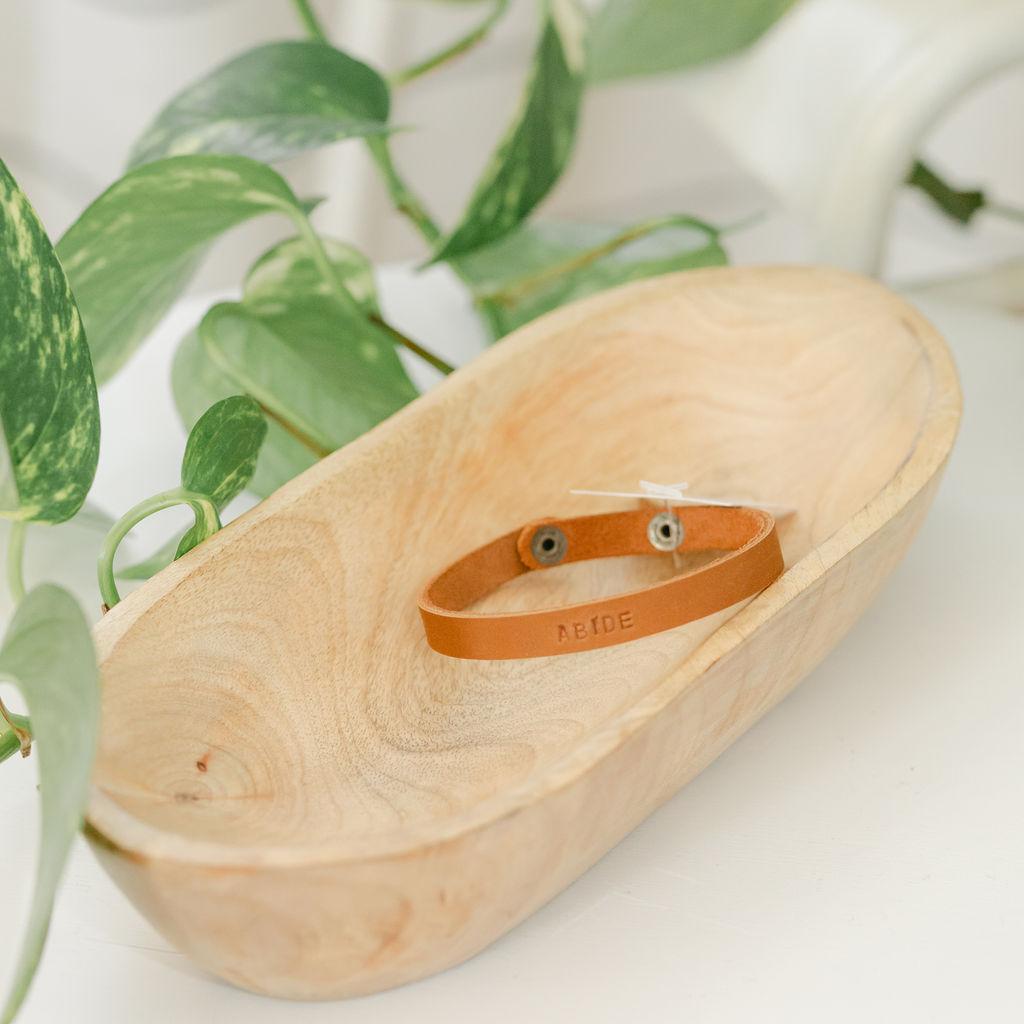 Close up of a light brown leather bracelet with &