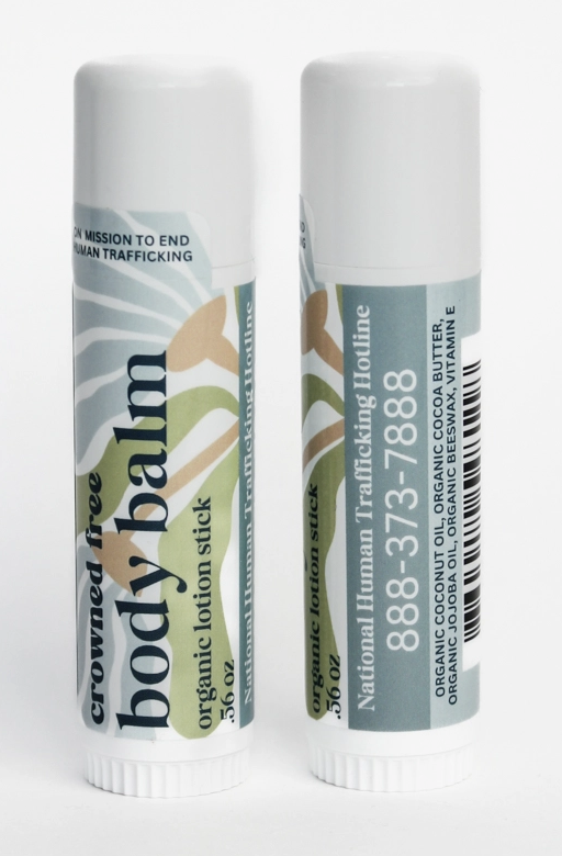 Two sticks of organic body balm with boho-inspired design on the label, including a toll-free number for the National Human Trafficking Hotline.