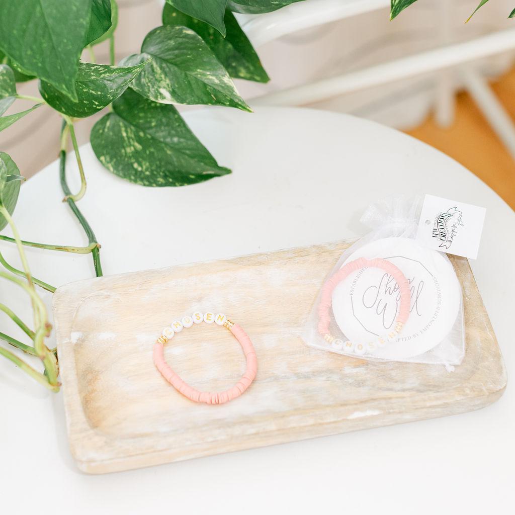 A pair of pink bracelets saying &