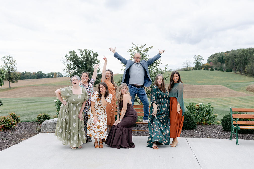 Group of people posing outdoors with a scenic background
