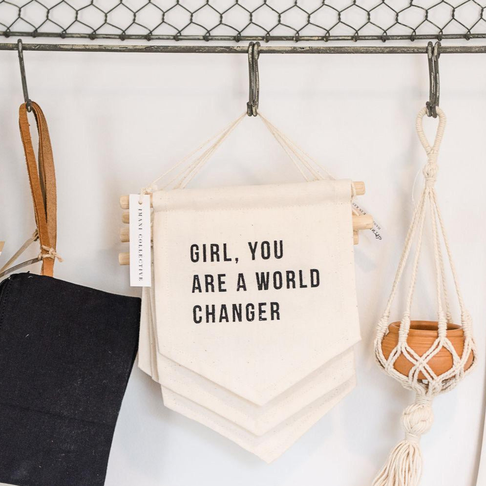 A canvas hanging sign with the text &