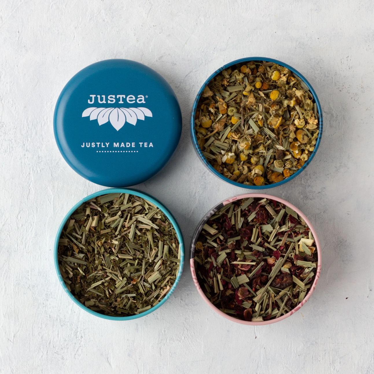 Top view of three tins of loose leaf tea. The turquoise lid says justea, justly made tea.