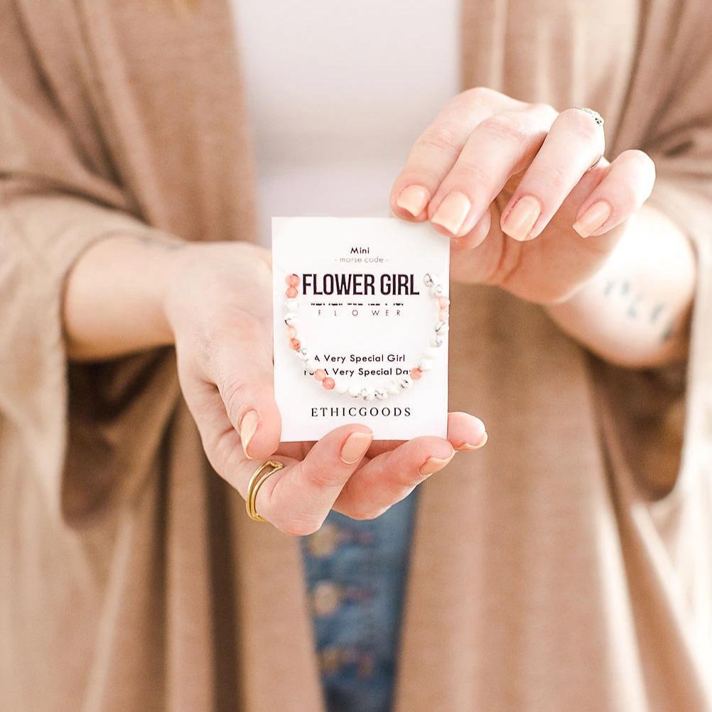 A person holding a packaged bracelet with a label that reads &