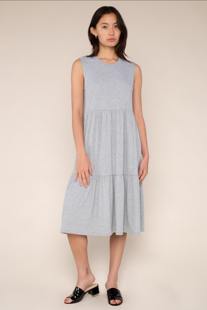 Woman wearing a light gray dress against a beige background