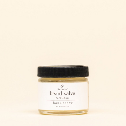 Jar of beard salve with a black lid on a beige background