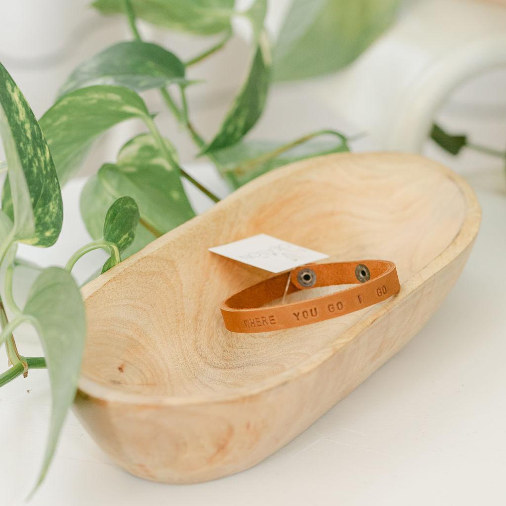 Close up of a light brown leather bracelet with &