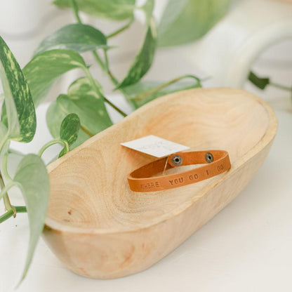 Close up of a light brown leather bracelet with &
