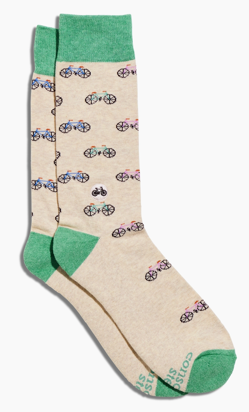 Beige socks with bicycle pattern and green accents on a white background