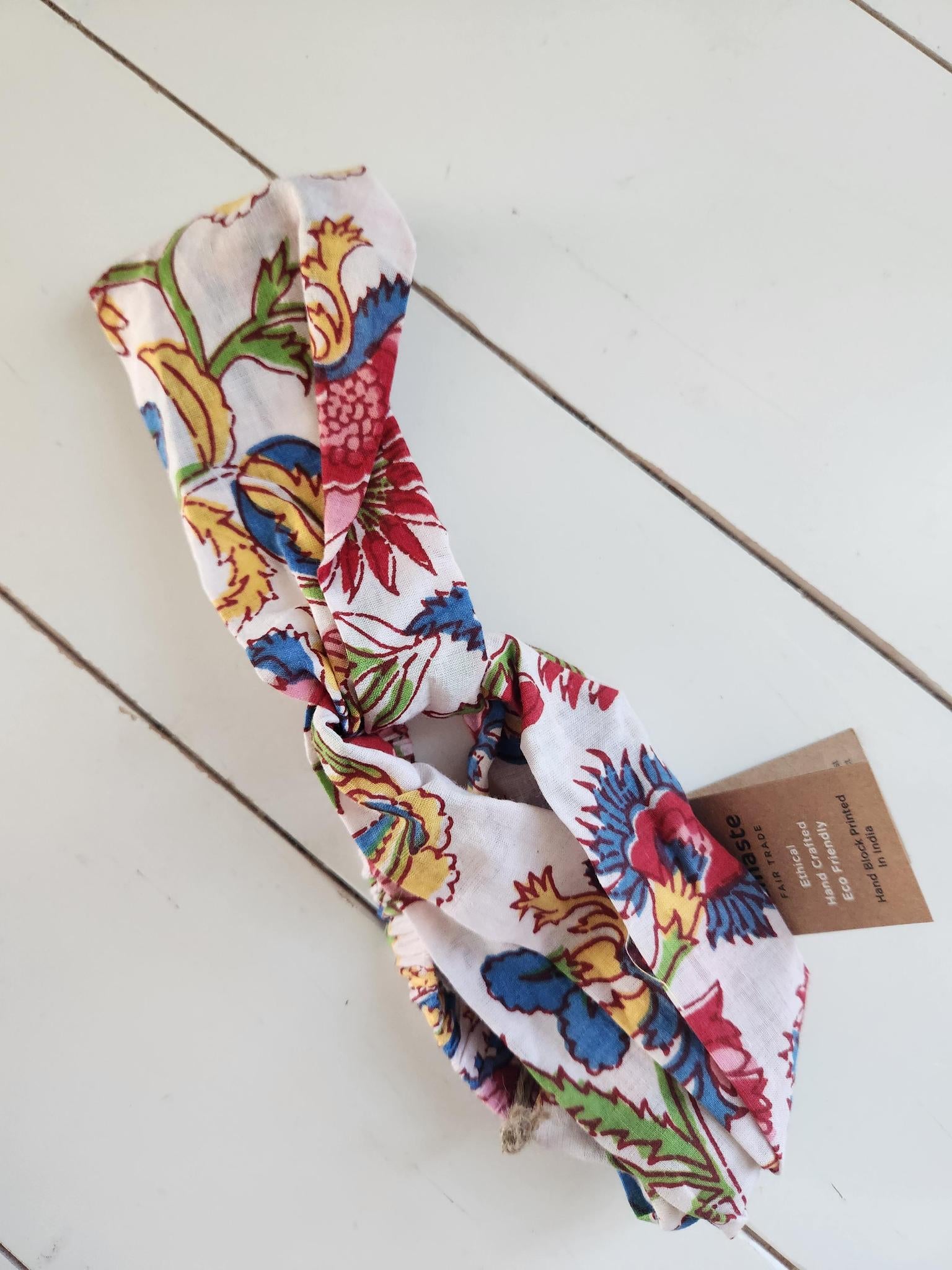 Colorful floral headband on a light wooden surface