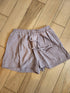 Pair of light brown shorts on a wooden floor