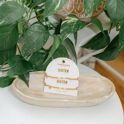 Set of two gold and pearl bracelets on a card saying &