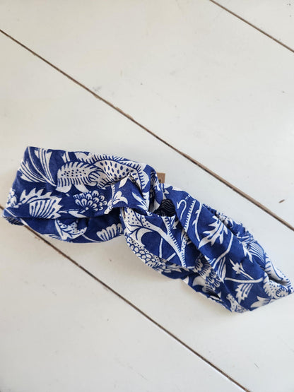 Blue and white patterned headband on a light wooden surface