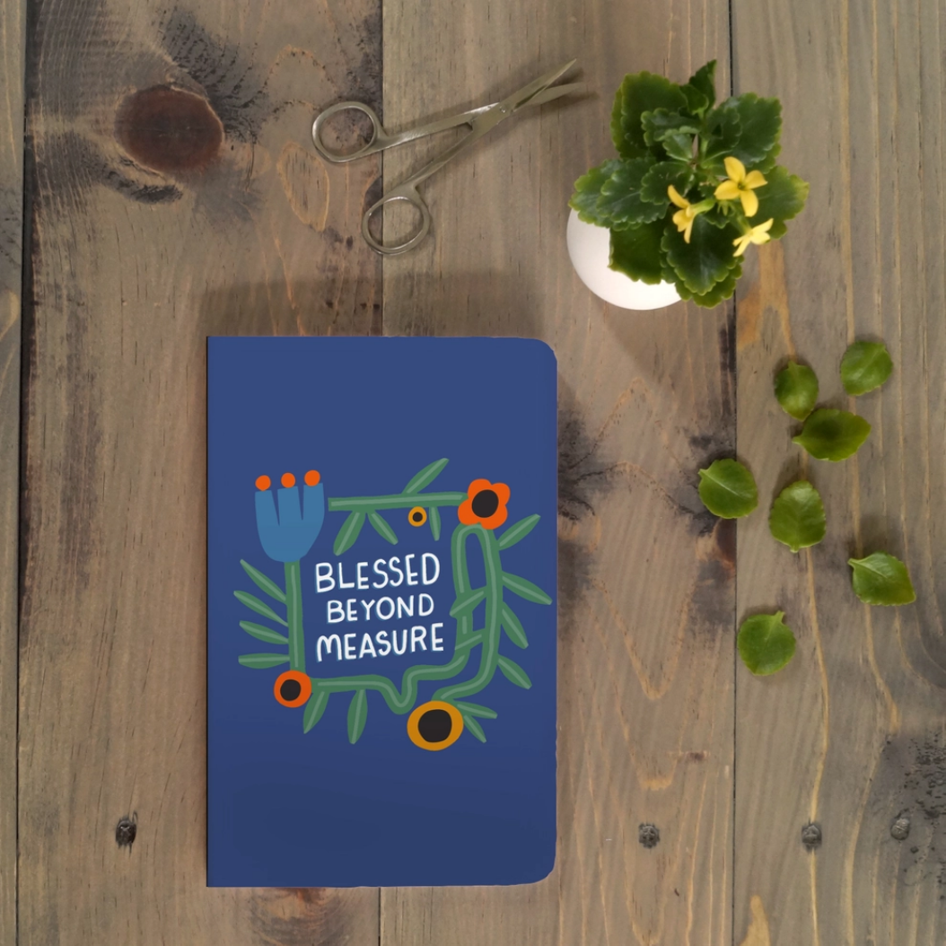 Blue notebook with floral design and text &