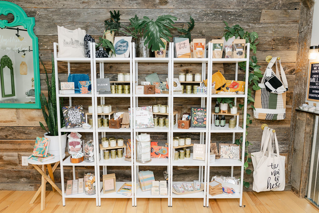 White shelving unit with various items against a wooden wall.