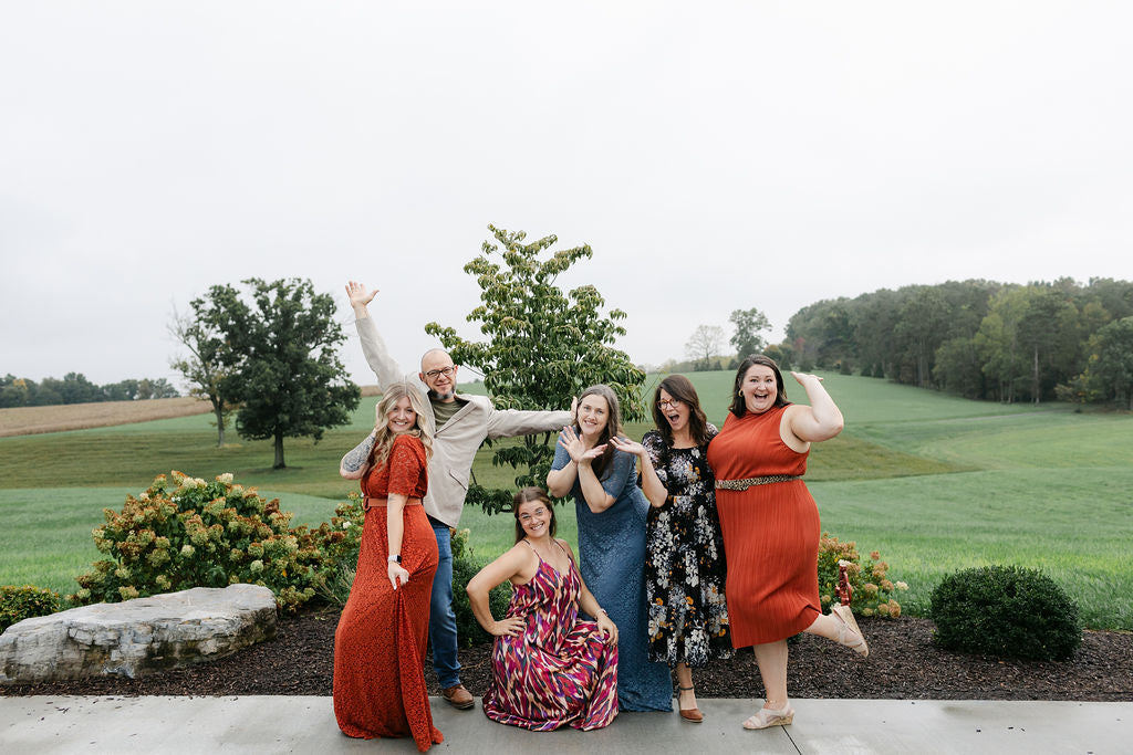 Group of people posing outdoors with a scenic background