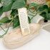 Bookmark with a quote on a wooden tray with plants in the background
