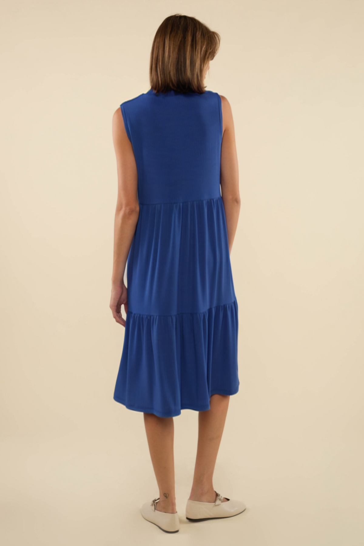 Woman wearing a blue dress on a beige background