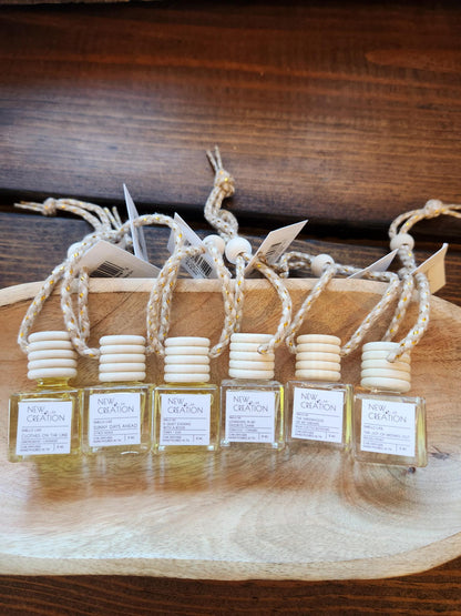 Five small glass bottles with labels on a wooden surface