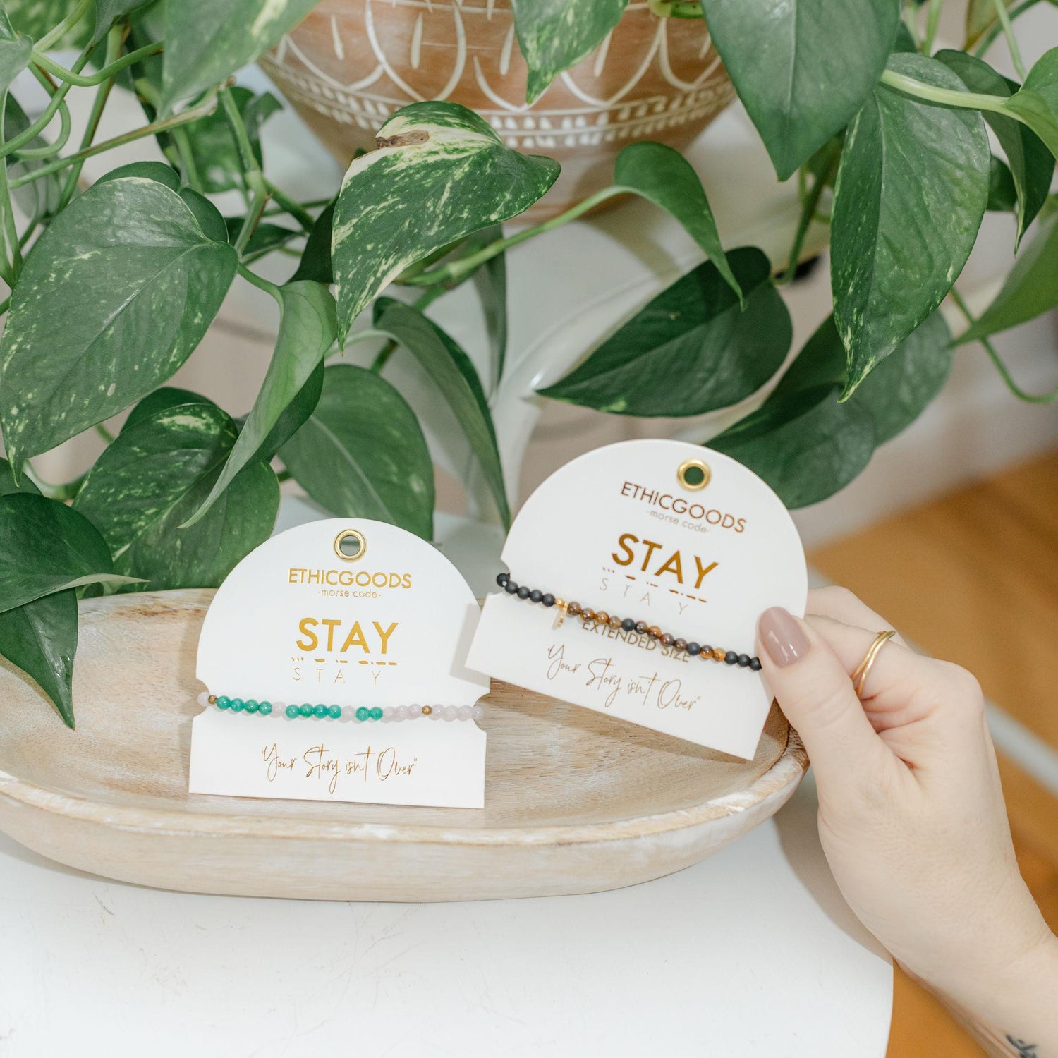 Two bracelets on white tags with &